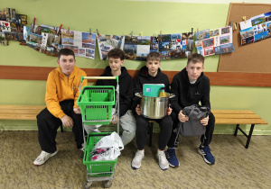 Uczniowie na korytarzu z koszykami sklepowymi i garnkiem zamiast plecaków