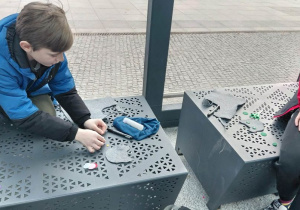 Chłopcy ozdabiają filcowe podkładki kolorowymi elementami z filcu.