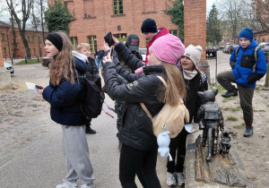 Uczestnicy odnaleźli kota szkolnego i robią sobie z nim zdjęcie.