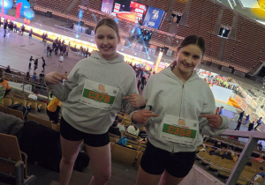 Dziewczynki prezentujące przydzielone numery startowe.