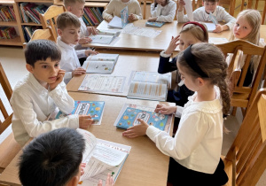 Uczniowie po pasowaniu w trakcie przygotowań do rozwiązywania zagadek bibliotecznych