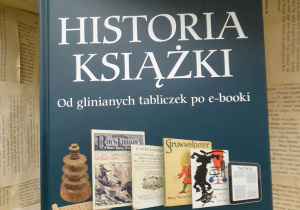 Zdjęcie przedstawia książkę, pt. „Historia książki. Od glinianych tabliczek po e-booki” pióra Rodericka Cave’a i Sary Ayad. Książka została ustawiona na regale wystawowym w bibliotece.