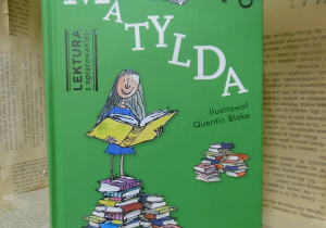 Zdjęcie przedstawia książkę ustawioną na regale wystawowym w bibliotece. Jest to jedna z bardziej znanych pozycji pióra Roalda Dahla - „Matylda”.