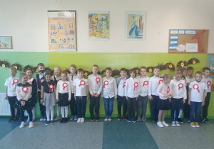 Uczniowie klasy IIa stoją na korytarzu i śpiewają hymn. Budynek A, 2 piętro
