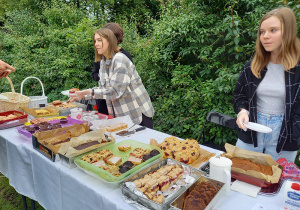 Wolontariuszki sprzedające własnoręcznie przygotowane ciasta podczas pikniku rodzinnego, z którego dochód przeznaczony był na opał dla ludzi znajdujących się w trudnej sytuacji życiowej