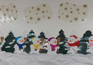 Zimowa dekoracja „Bałwany w śniegu” wykonana z bibuły, kolorowego papieru i pluszu.