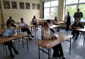 Uczniowie siedzący w ławkach przed egzaminem w sali nr 3.
