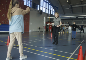 Uczniowie klas VI rywalizują w skokach przez skakankę.