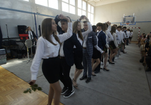 Uczniowie w parach tańczą poloneza.