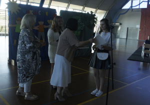 Lena Sztandor - uczennica z najwyższą średnią w szkole - odbiera nagrodę od pani dyrektor Moniki Łobody