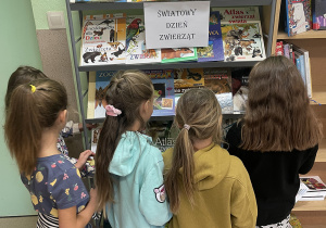 Dzieci oglądają wystawę książek z okazji Światowego Dnia Zwierząt