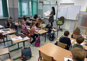 Klasa 1B słucha opowiadania czytanego przez Panią Bibliotekarkę.