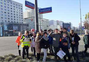 Uczestnicy wycieczki przy tabliczce z napisem aleja Marszałka Józefa Piłsudskiego