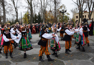 Członkowie Zespołu Pieśni i Tańca "Rzgowianie" wykonujący poloneza przed Urzędem Miejskim w Rzgowie.