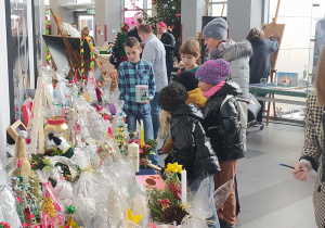 Dzieci wybierające ozdoby świąteczne na stoisku.