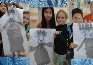 Uczniowie trzymają w rękach wykonane ze srebrnego papieru suknie Królowej Śniegu.