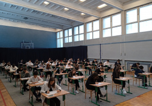 Uczniowie na dużej sali gimnastycznej podczas próbnego egzaminu ósmoklasisty