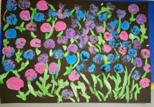 Duży plakat przedstawiający Kolorowe kwiaty na czarnym tle. Praca wykonana w grupie III pod opieką Pani A. Kawełczyk.