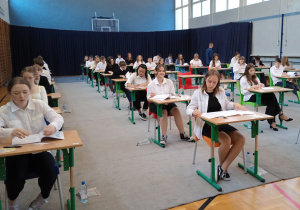 Uczniowie przed egzaminem na dużej sali gimnastycznej